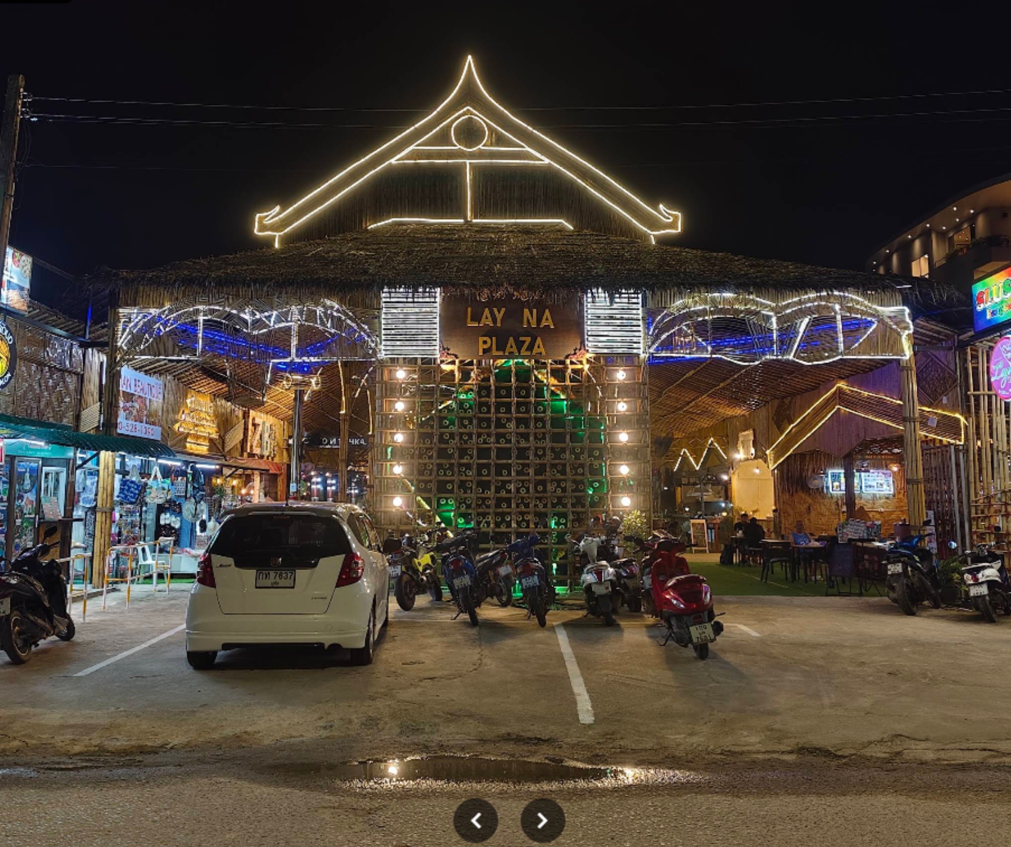 Layna Plaza entrance at night in Bang Tao Phuket with traditional Thai roof and warm lights